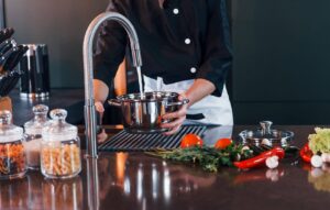 Įranga restoranų virtuvėms, virtuvės darbuotojas naudojasi plautuve restorano virtuvėje | Horeca
