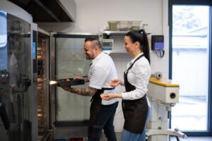 Konvekcinė krosnis ir ja besinaudojanti virtuvėje dirbanti moteris ir vyras | Horeca shop